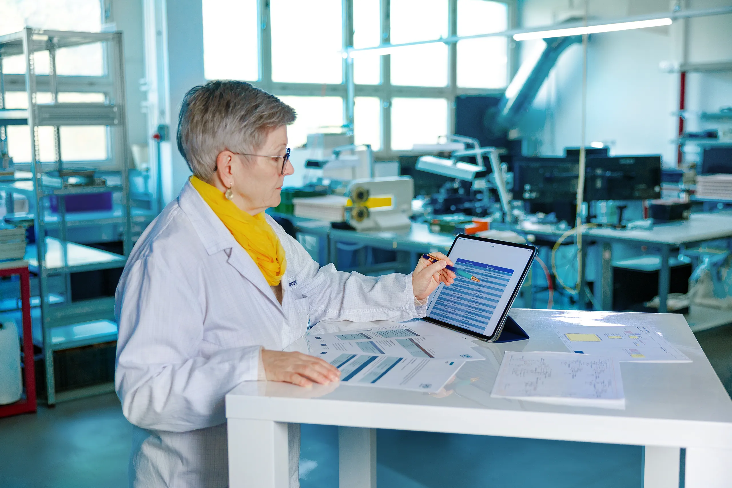 Mitarbeiterin prüft technische Unterlagen und Daten auf einem Tablet